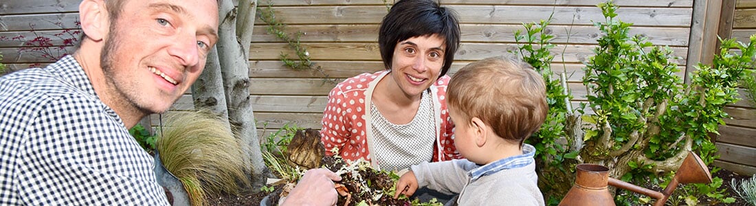 Famille zéro déchet face à un composteur