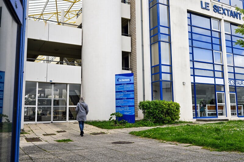 Photo du batiment avec une femme entrant à l'intérieur