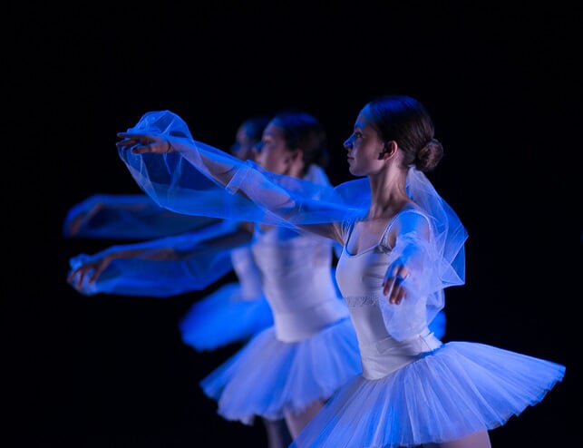 Trois adolescentes danseuses classiques sur scène, en tutus et justaucorps
